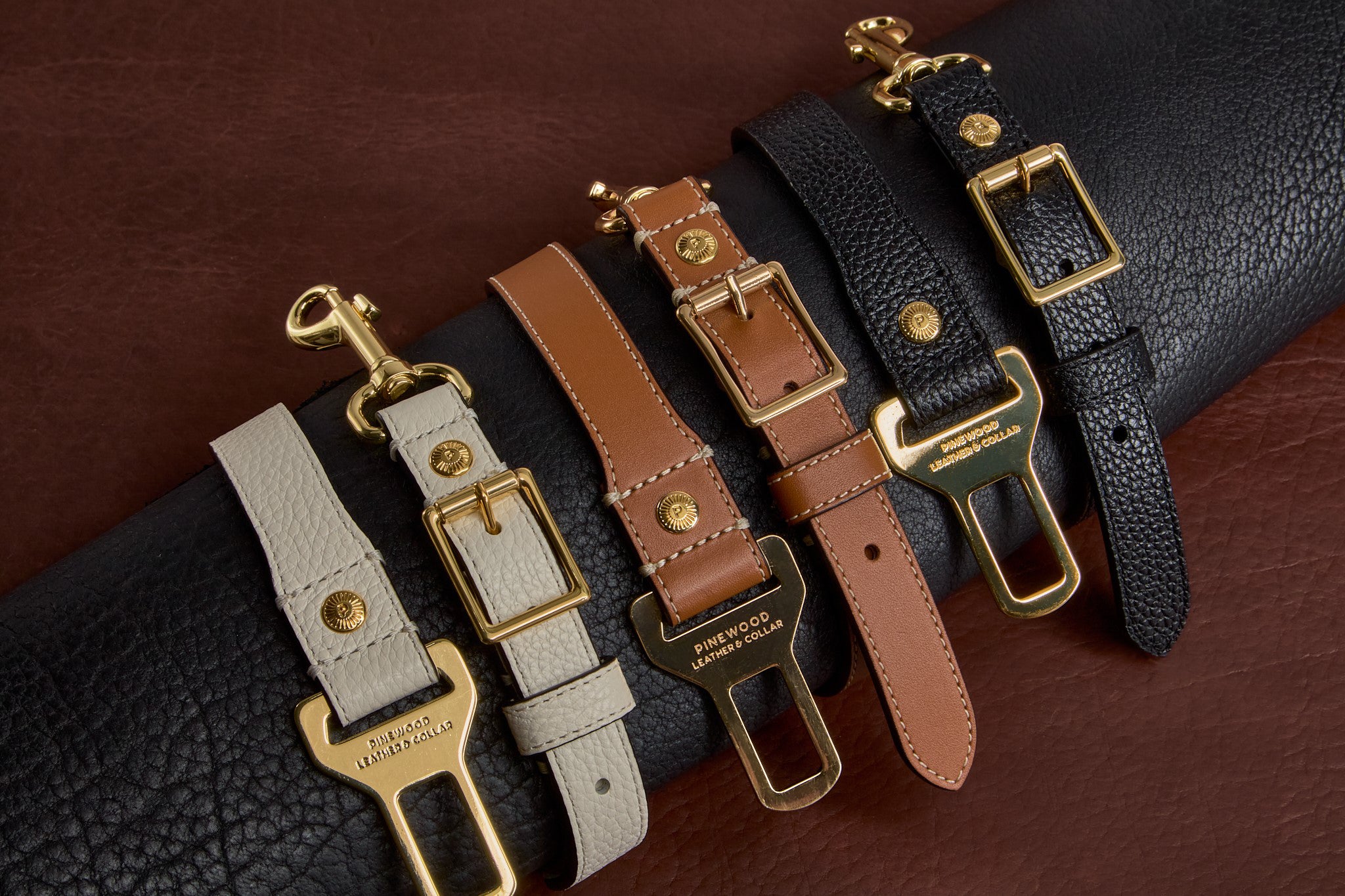 Luxury leather dog seatbelt tethers in tan, black, and white with gold hardware – Pinewood Leather & Collar, a Nashville brand.